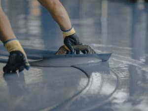 Resina autolivellante per impermeabilizzazioni continue Applicazione manuale di resina liquida autolivellante su superficie per impermeabilizzazione